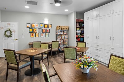 Activity room with tables and chairs, colorful decor.