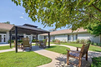 Outdoor seating area with shaded gazebo and landscaped gardens