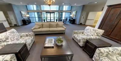 A cozy common area with seating in a senior living facility