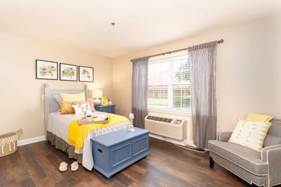 Cozy resident room with bed, chair, and decor