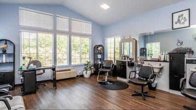 Bright beauty salon with styling chairs and large windows