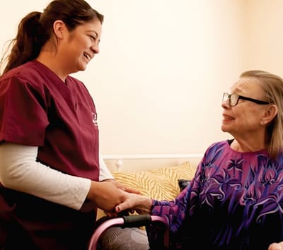 Caregiver interacting with a senior resident in a room