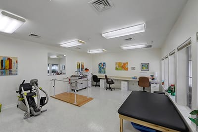 Bright therapy room with exercise equipment and artwork
