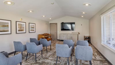 Bright common area with chairs and a piano