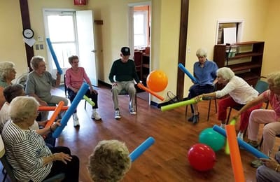 Residents participating in an activity with pool noodles