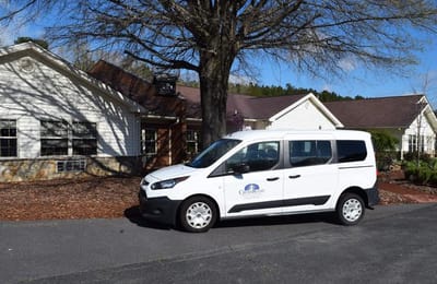 Exterior view of a facility with a transport van
