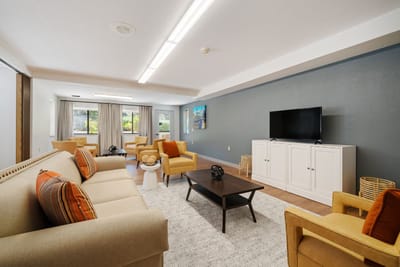 Bright common area with comfortable seating and a TV