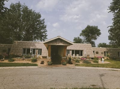 Exterior view of Dakota Estates Retirement Center with gardens