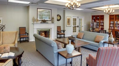 Brightly lit common area with seating and a fireplace