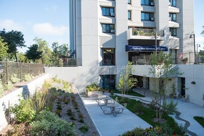 Exterior view of Ebenezer Tower Apartments with landscaped patio.