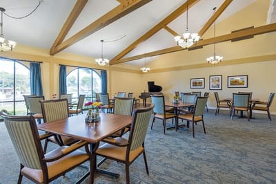 Common area with tables and chairs in a well-lit room