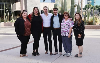 Staff members posing together outdoors.