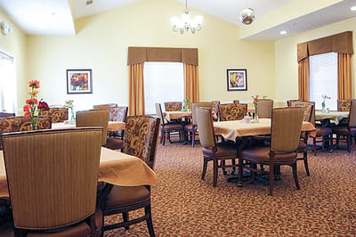 Dining room with tables and chairs set for residents