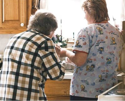 Caregiver assisting a resident in a kitchen setting