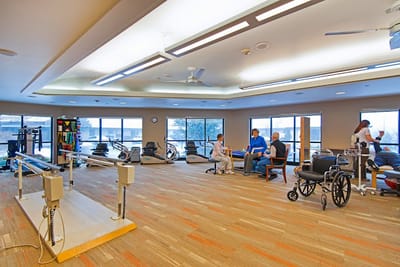 Residents engaged in physical therapy in a bright room