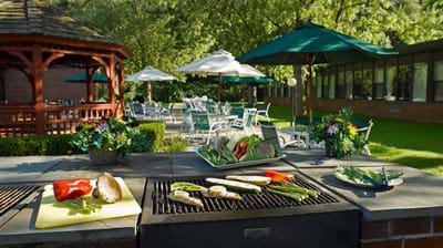 Outdoor grilling area with fresh vegetables and seating