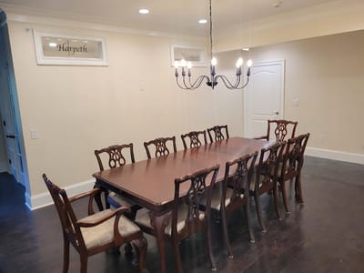 Dining area with a large wooden table and chandelier