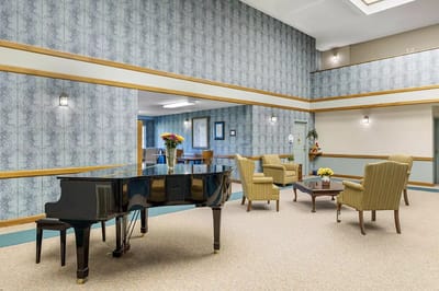 Bright interior common area with a piano and seating