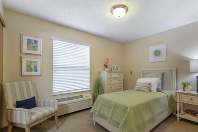 Cozy private resident room with a bed and chair