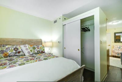 A cozy resident room with a colorful bedspread and closet