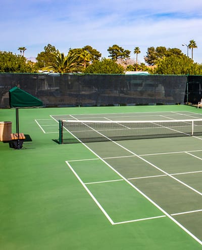 Outdoor tennis court surrounded by greenery