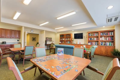 Bright common area with puzzle tables and bookshelves