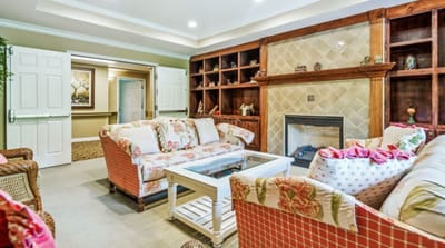 Cozy common area with floral sofas and fireplace