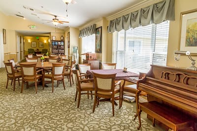 A cozy common area with seating and a piano