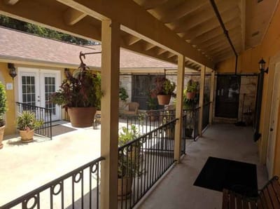 A corridor with plants leading to resident doors