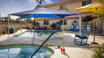 Swimming pool area with lounge chairs and shade