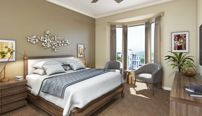 A well-furnished resident room with large windows