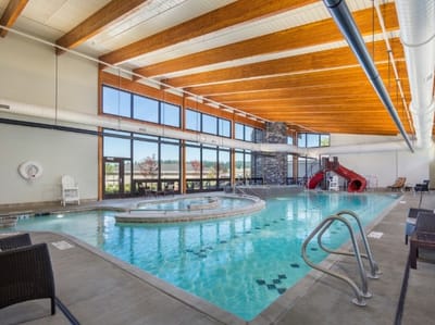 Indoor pool area with a waterslide and seating
