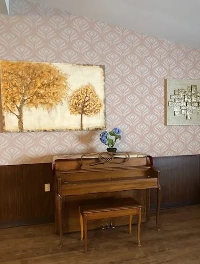 Piano in a common area with decorative artwork