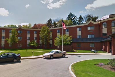 Exterior view of Seneca Place Village with greenery and cars