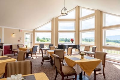 Bright dining area with large windows and tables