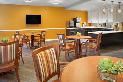 Common area dining space with wooden tables and chairs