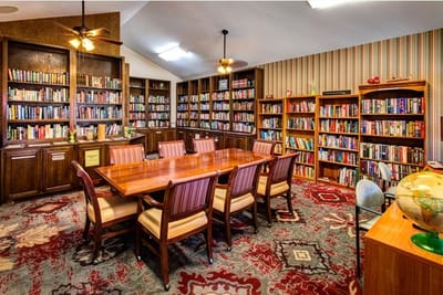 Bright common area with bookshelves and a large table