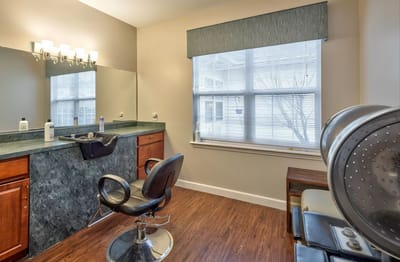 Hair salon area with a mirror and styling chair
