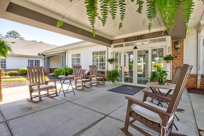 Welcoming front porch with rocking chairs at senior living facility