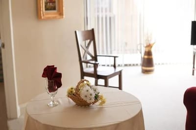 A neatly arranged table with flowers in a common area