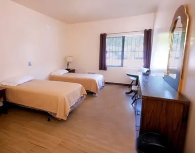 A shared bedroom with two beds and simple decor