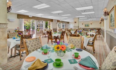 Bright dining room set for a meal with flowers and table settings