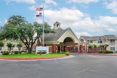 Front entrance of a senior living facility with flags