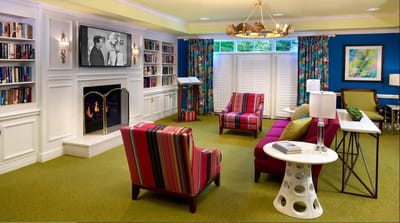 Bright common area with colorful seating and a fireplace