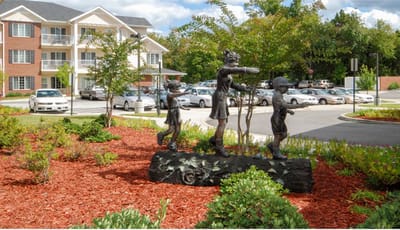 Sculpture of children playing in front of the facility