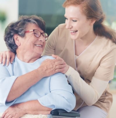 A caregiver interacting with a smiling resident.