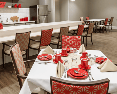 Dining area set with red tableware and decorations
