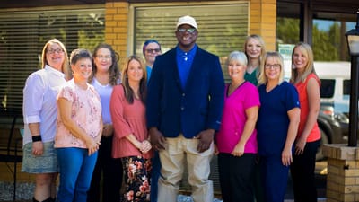 Staff posing together outside the facility