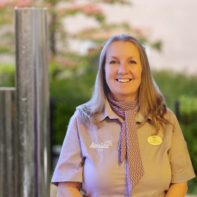Staff member smiling outdoors at the facility