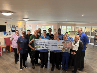 Staff and residents celebrating a good rating in a common area